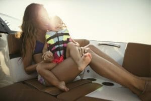 A woman is holding her child on a Supreme boat.