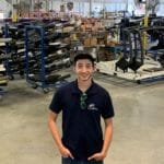 A young man in a warehouse full of Supreme Boats equipment.