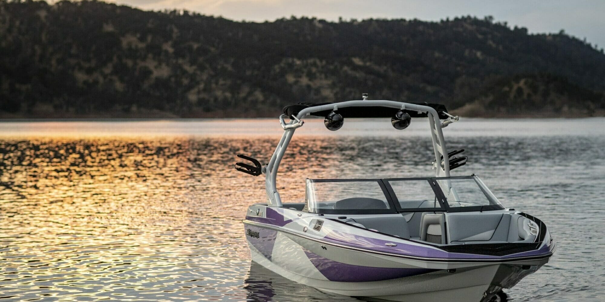 A Supreme boat sits on a lake at sunset.