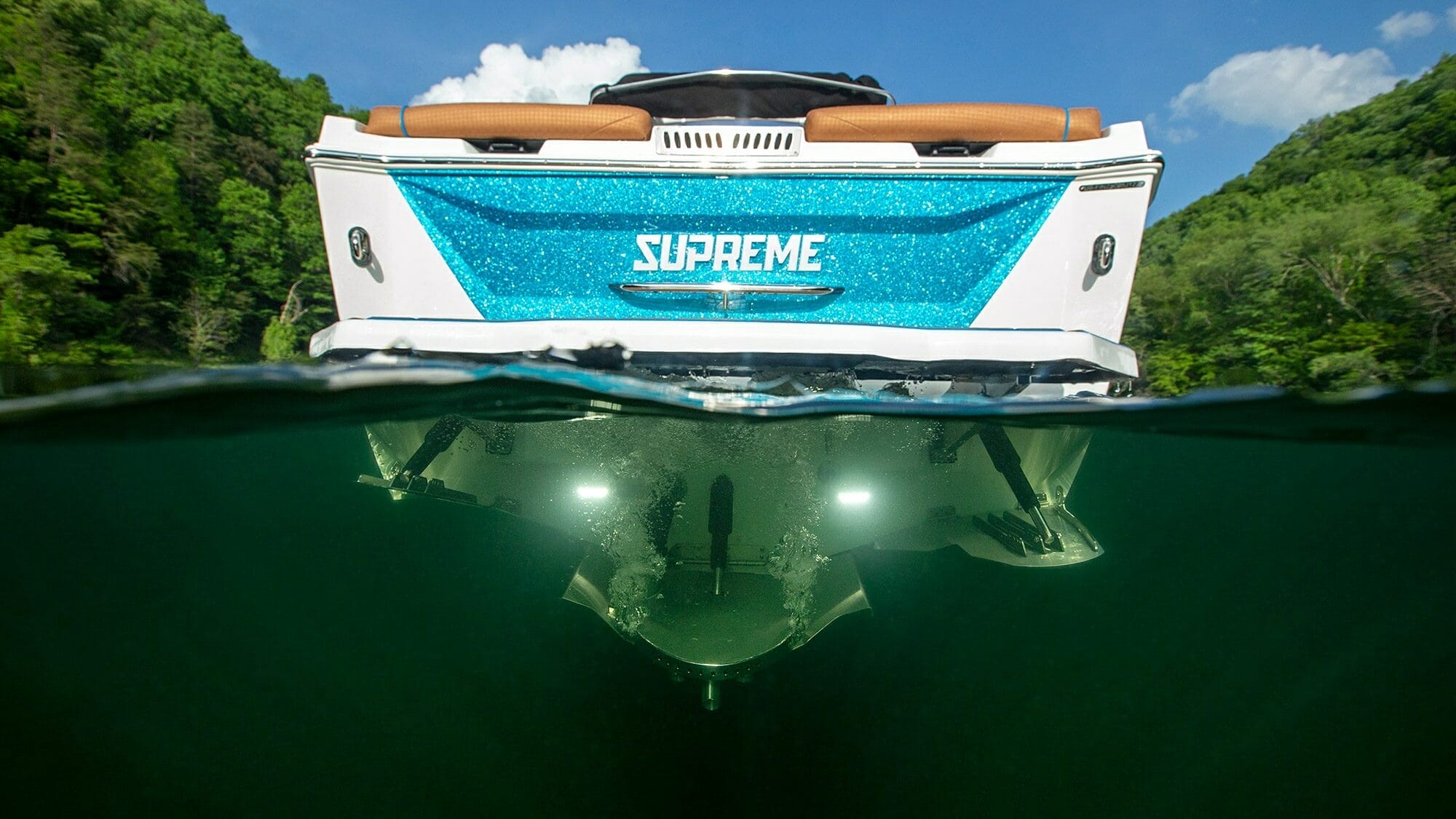 A Supreme boat with a blue and white hull in the water.