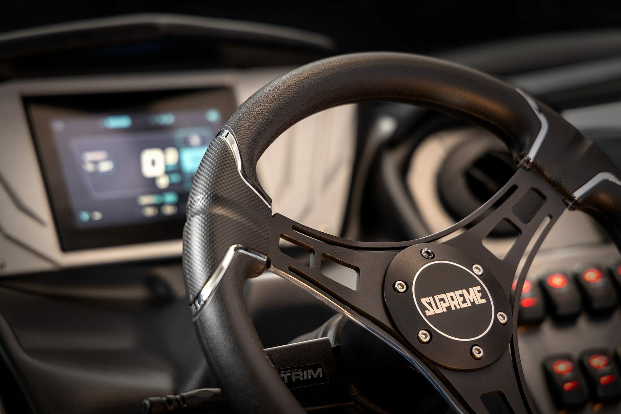 A steering wheel and dashboard in a Supreme car.