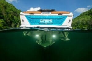 A blue and white Supreme boat in the water.