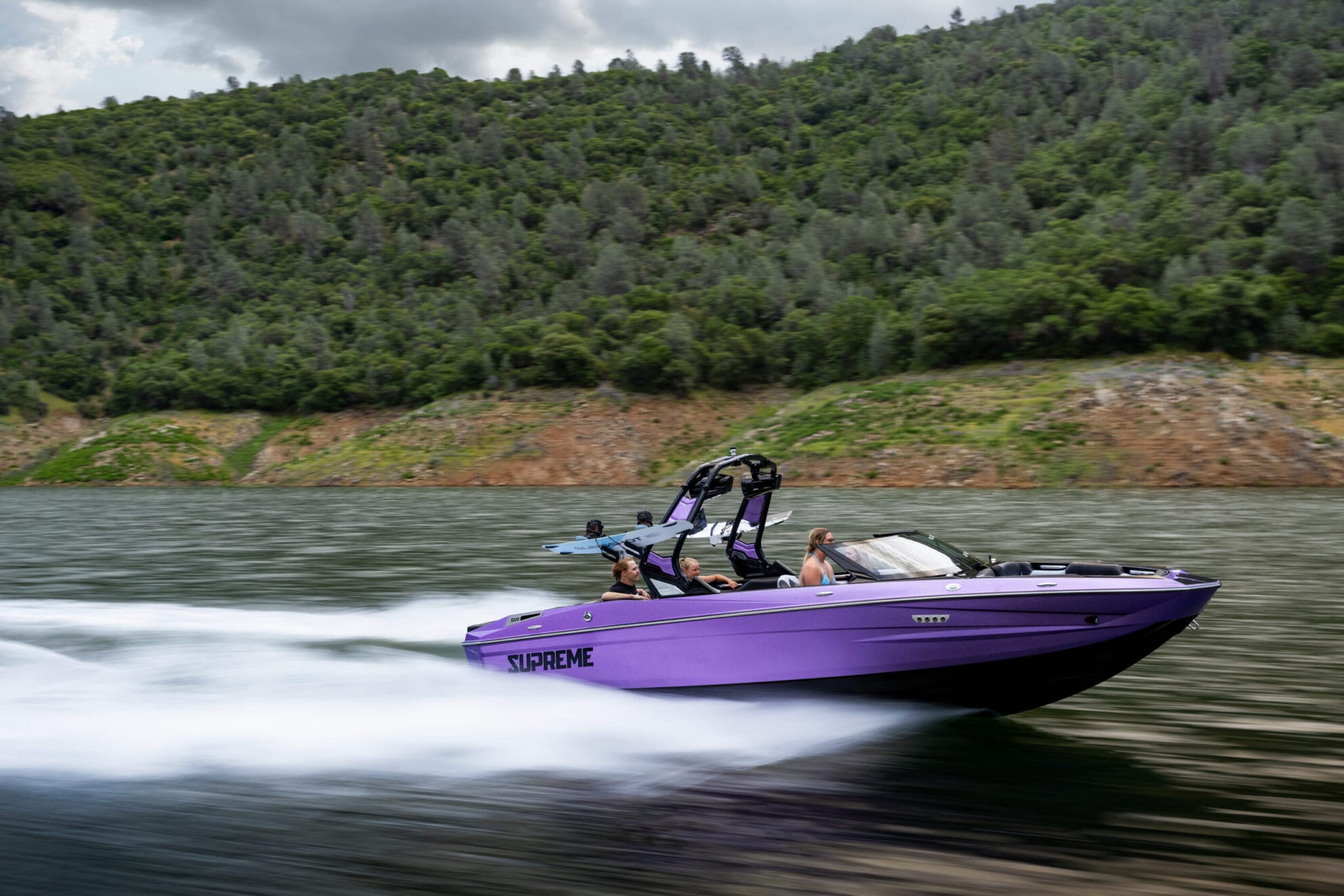 Purple S220 Supreme boat cruising in water.