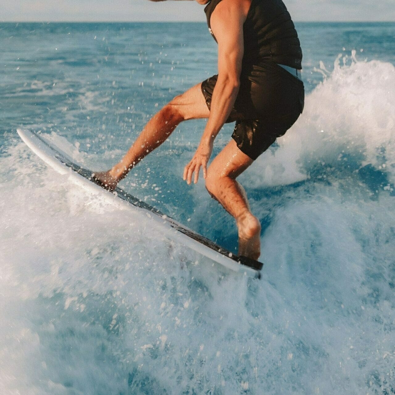 A man surfing on a Supreme surfboard.
