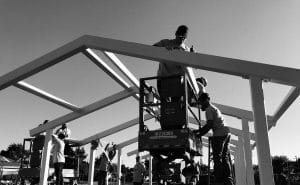 A black and white photo of men working on a roof.
