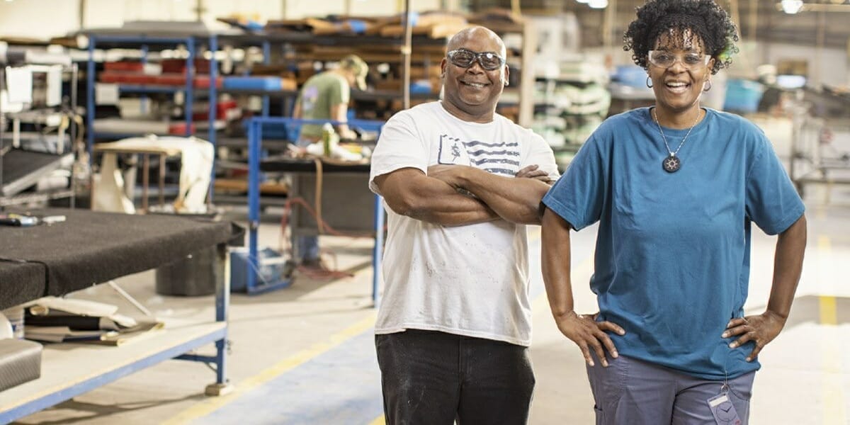 Two people standing in a factory manufacturing Supreme Boats.