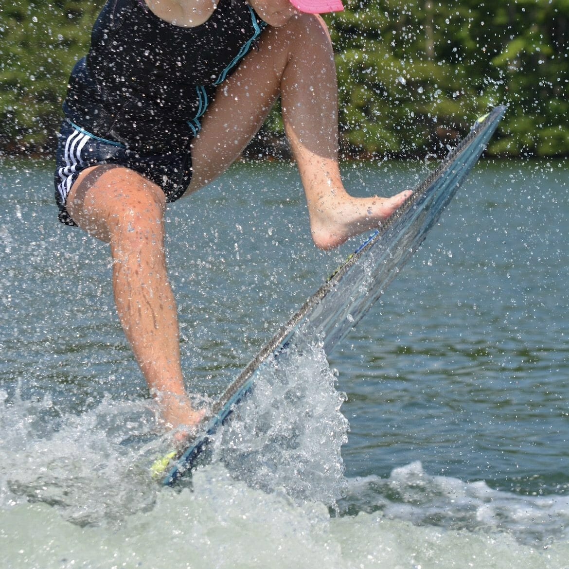 A girl is surfing on a Supreme surfboard.