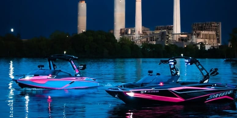Experiencing the transformative power of water sports as two jet skis navigate the night near a power plant.
